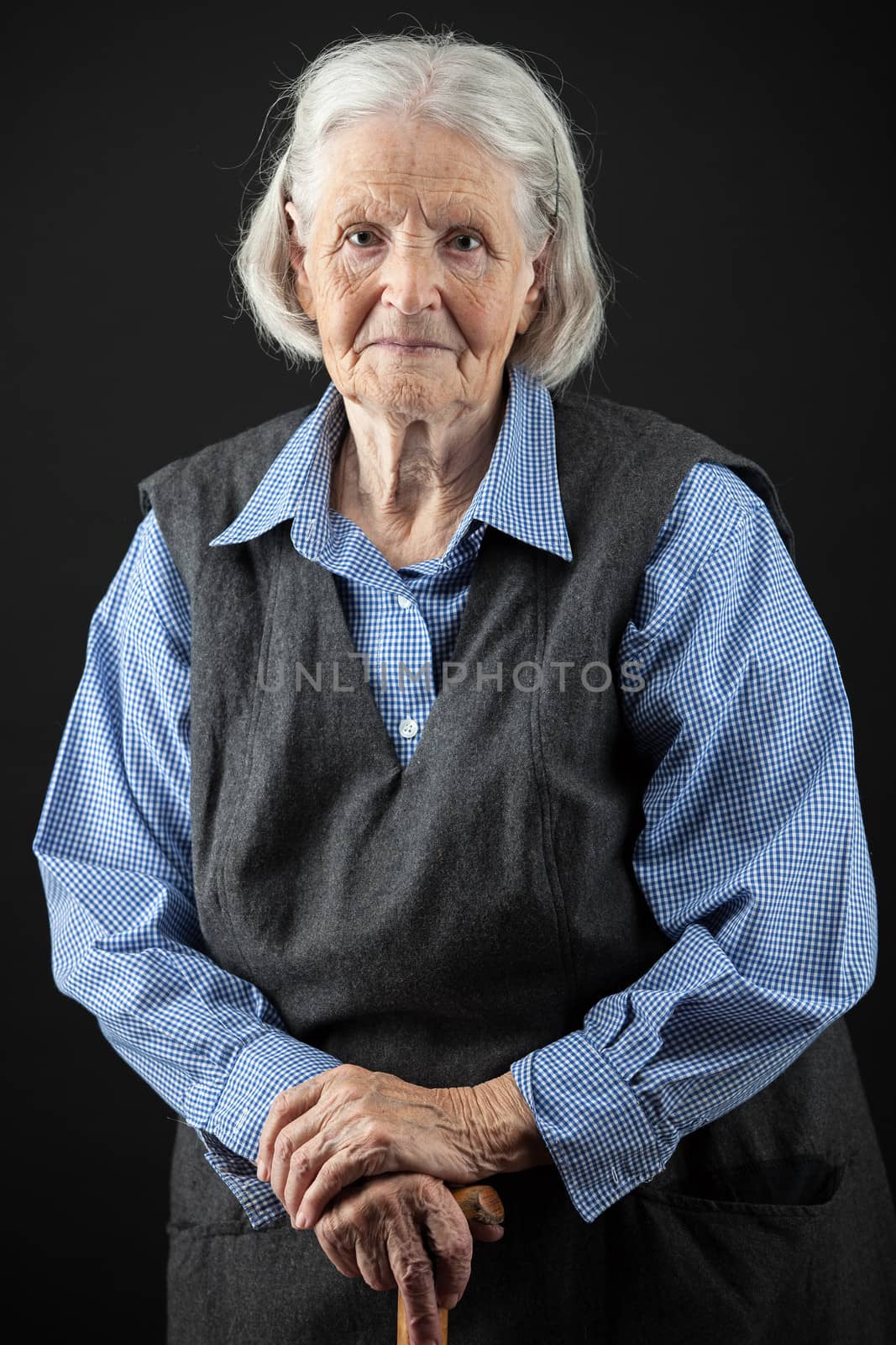 Portrait of a smiling senior woman looking at the camera over black