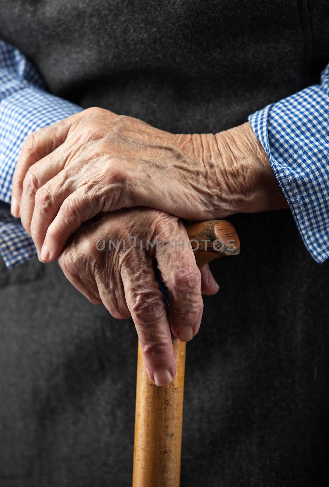 Closeup of senior woman's hands on walking stick by photobac