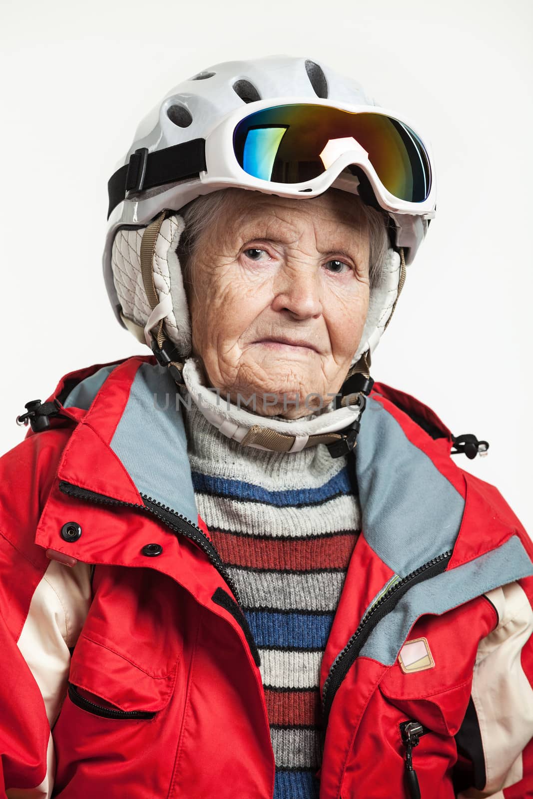 Portrait of senior woman in ski jacket and helmet over white
