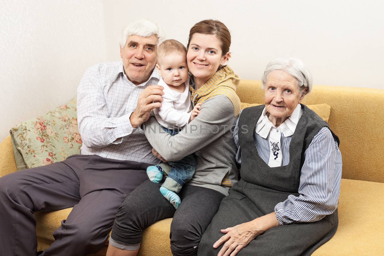 Four generation family sitting on sofa by photobac