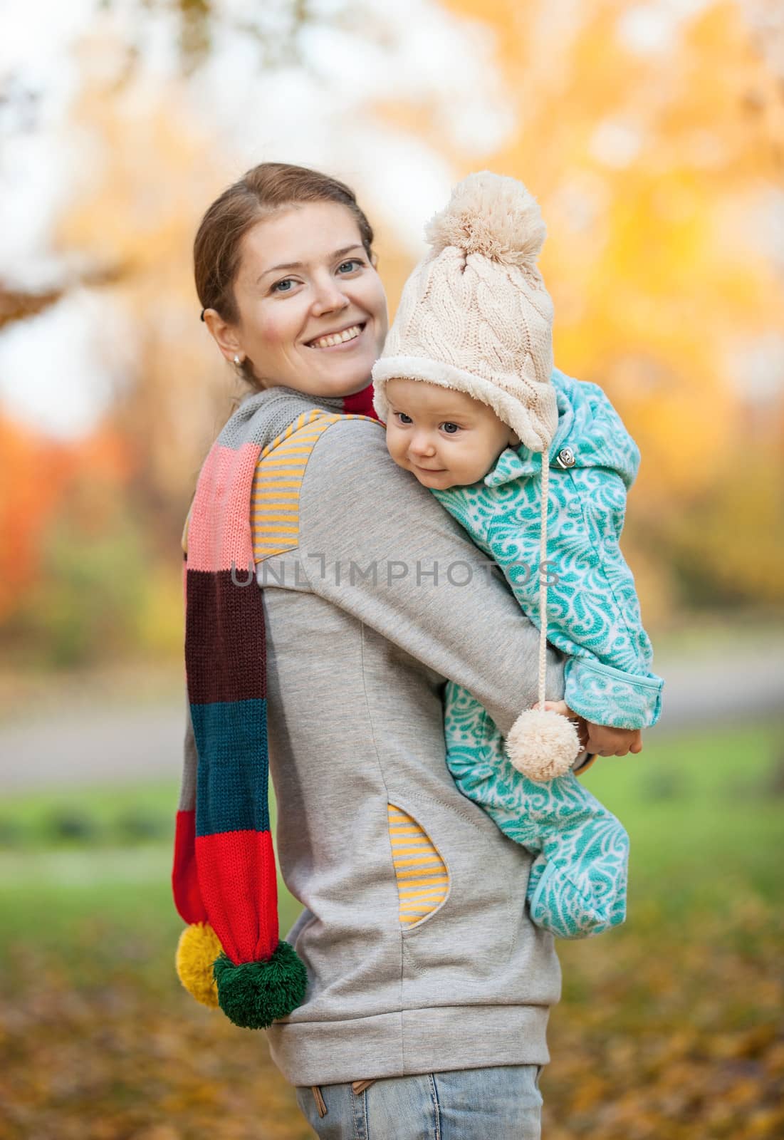 Portrait of young woman and her baby son in park by photobac