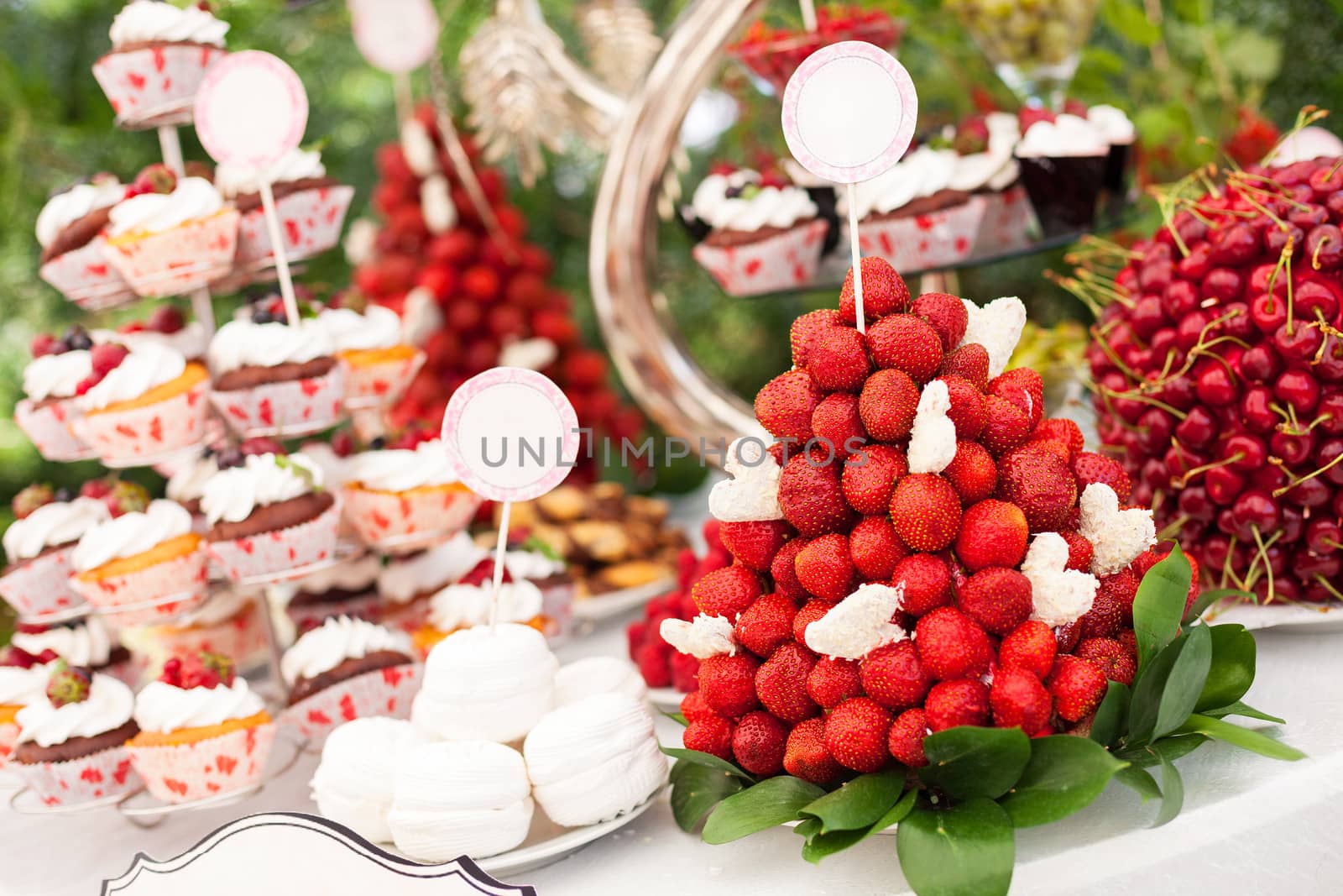 Sweet bar with cupcakes, fresh strawberries, and cherries