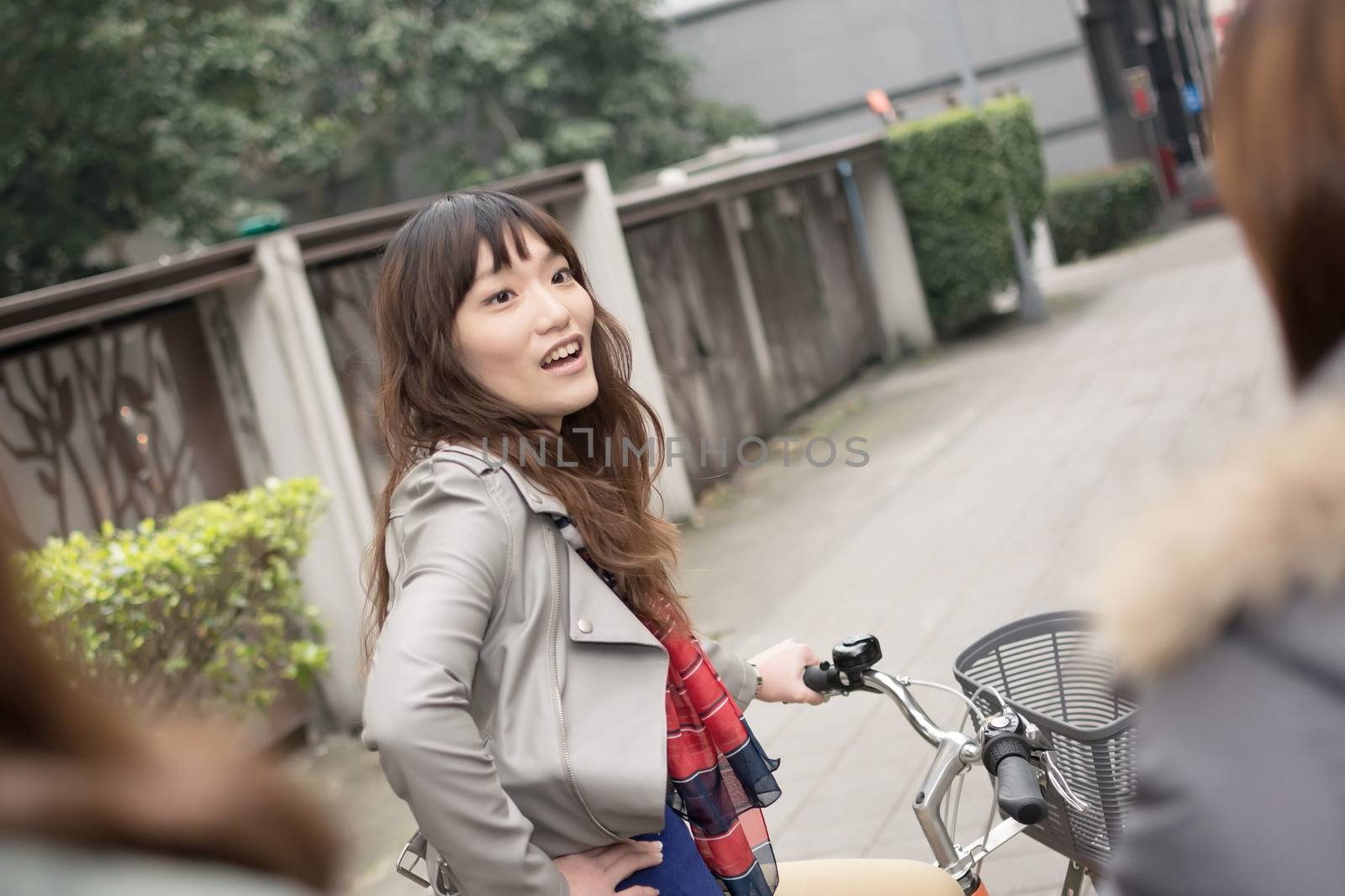 Young Asian woman riding bicycle with friends in city, Taipei, Taiwan.
