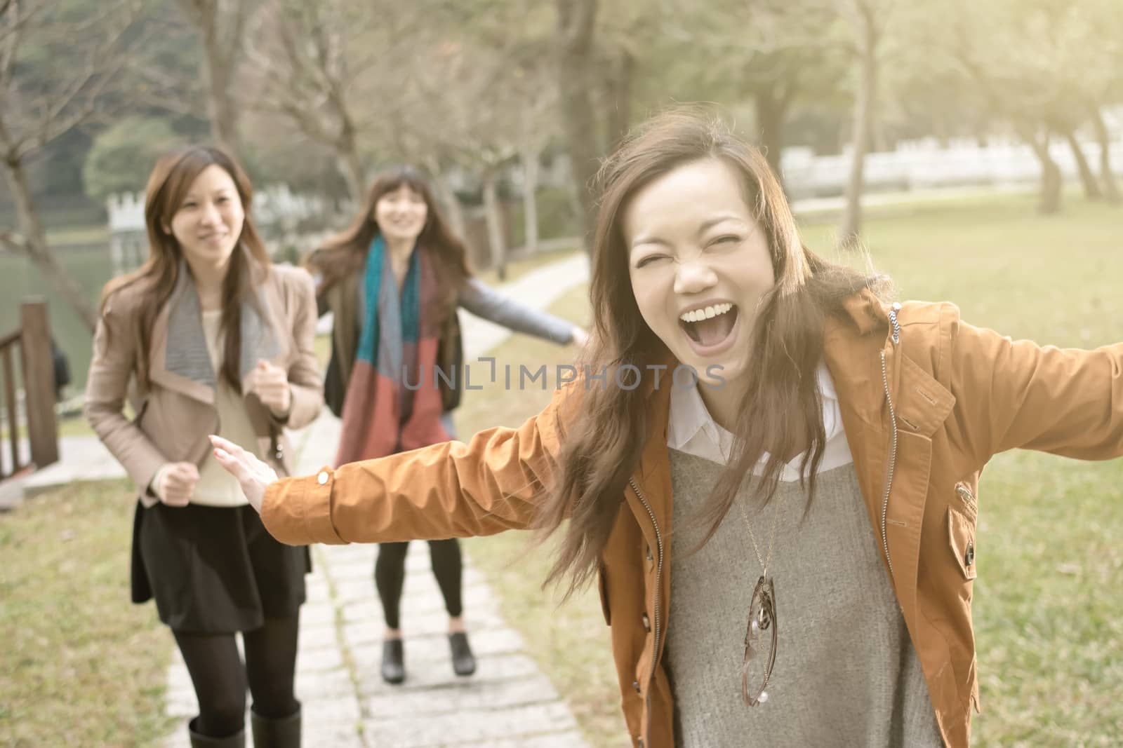 Happy smiling Asian women playing in the park by elwynn