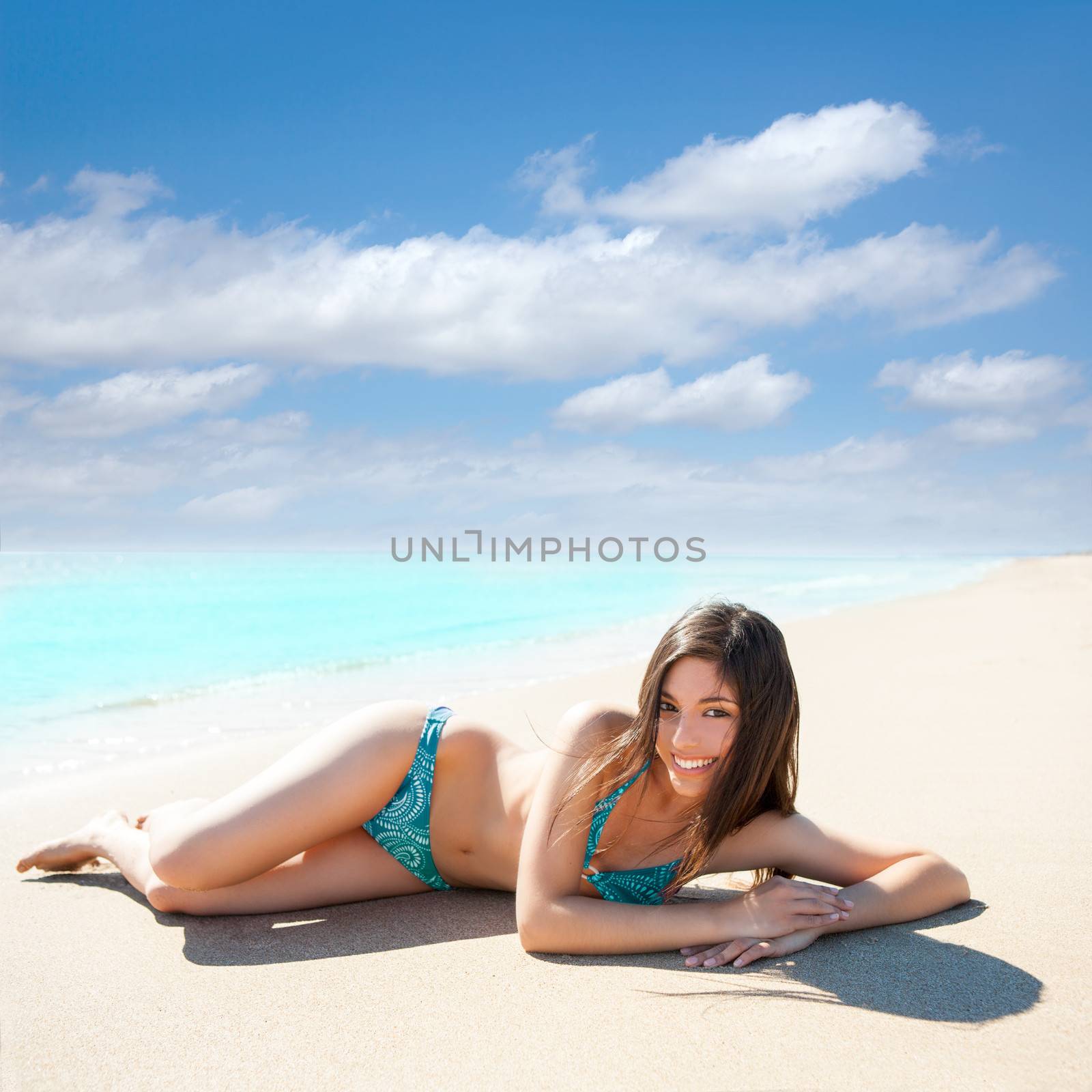 Asian brunette girl lying on the summer beach white sand by lunamarina
