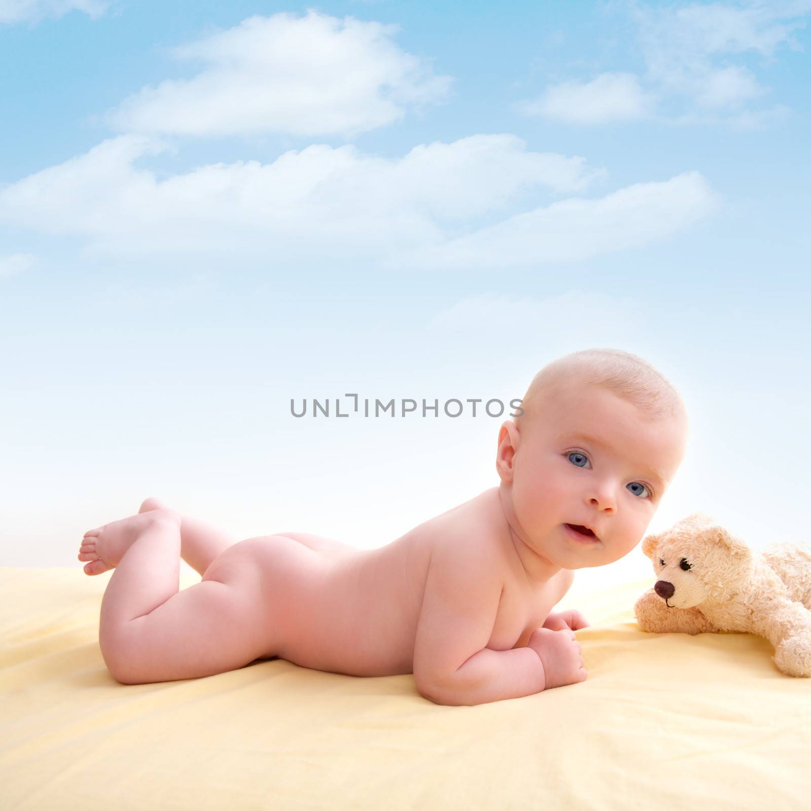 Bond little baby blue eyes lying down smiling on light yellow bed