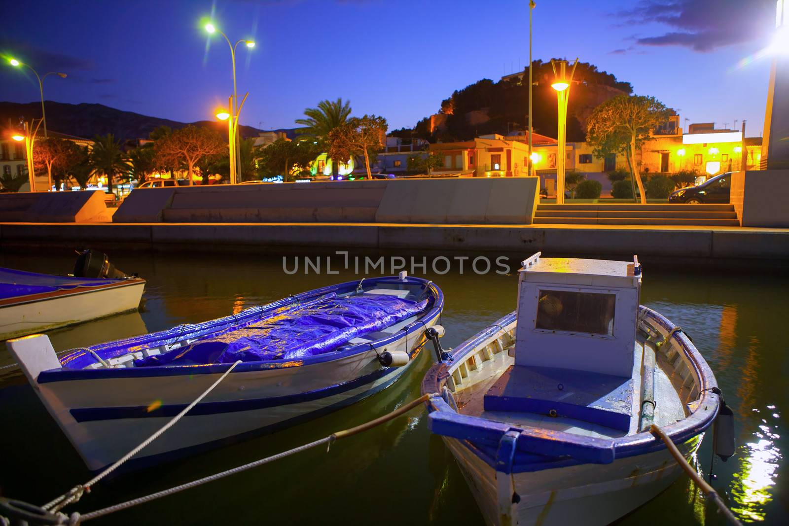 Denia port marina with traditional llaut boats at sunset night by lunamarina