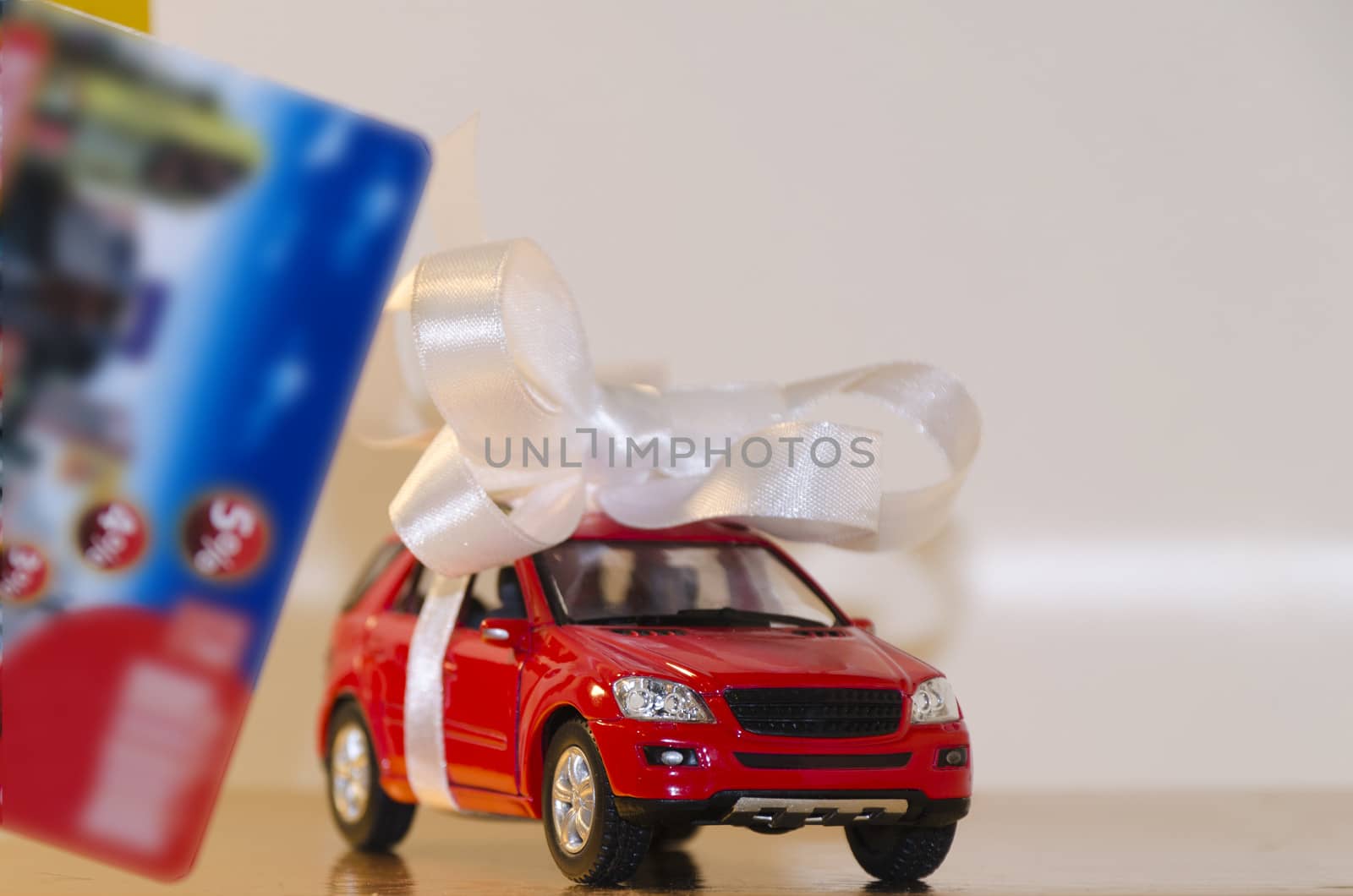 Red machine in a white ribbon and a discount card in the foreground