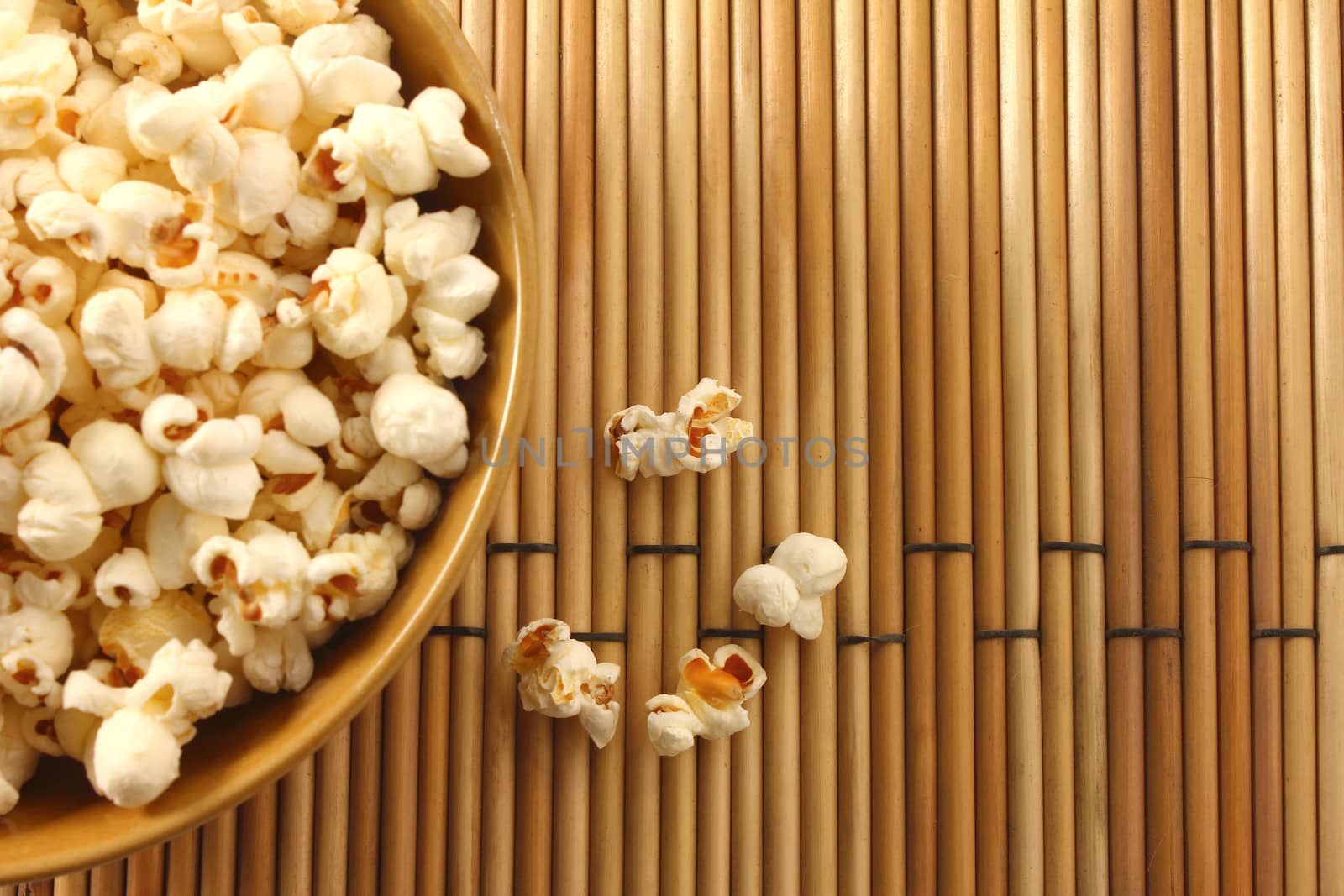 popcorn in bowl and spreading two or three corn mat background