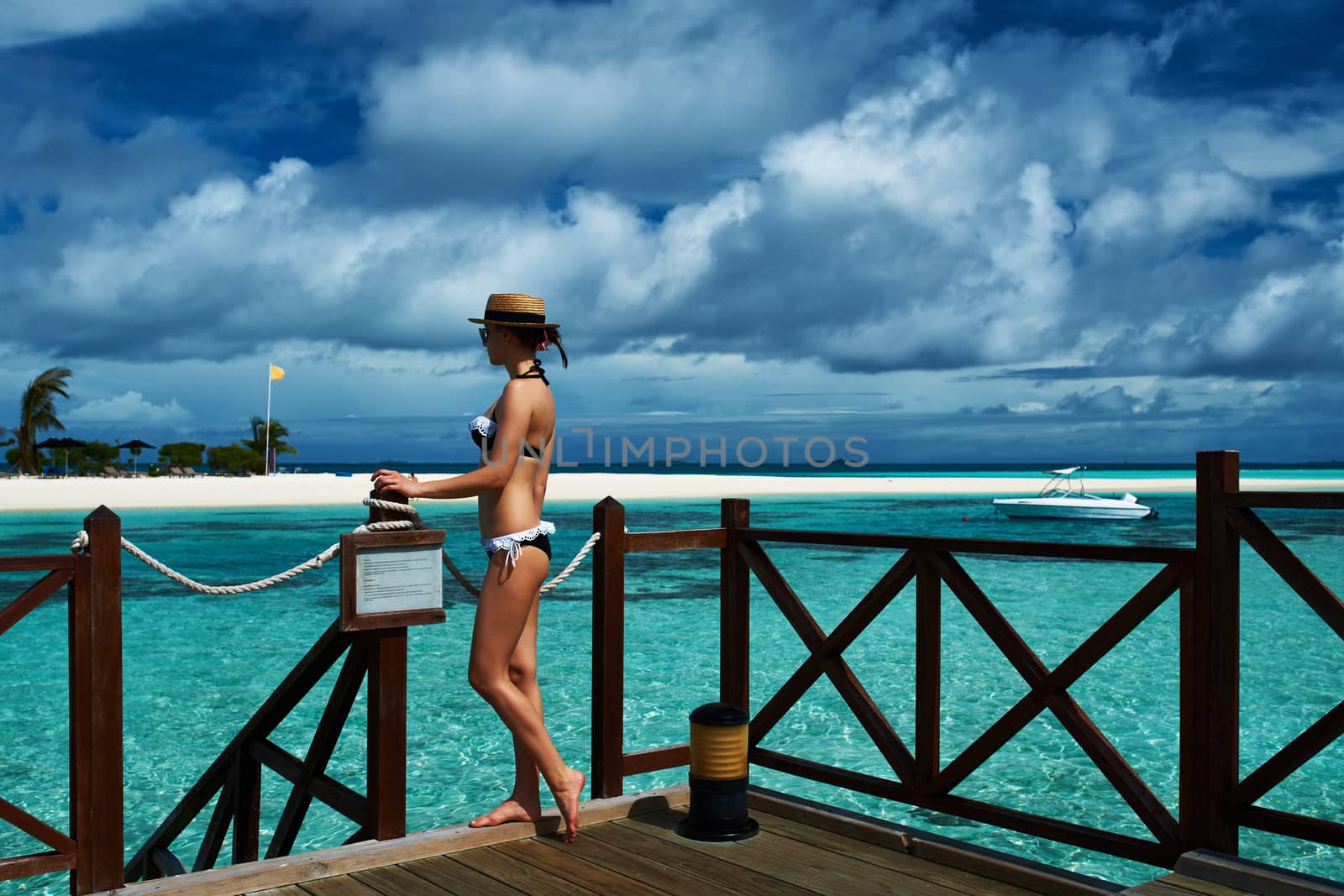 Woman on a tropical beach jetty at Maldives