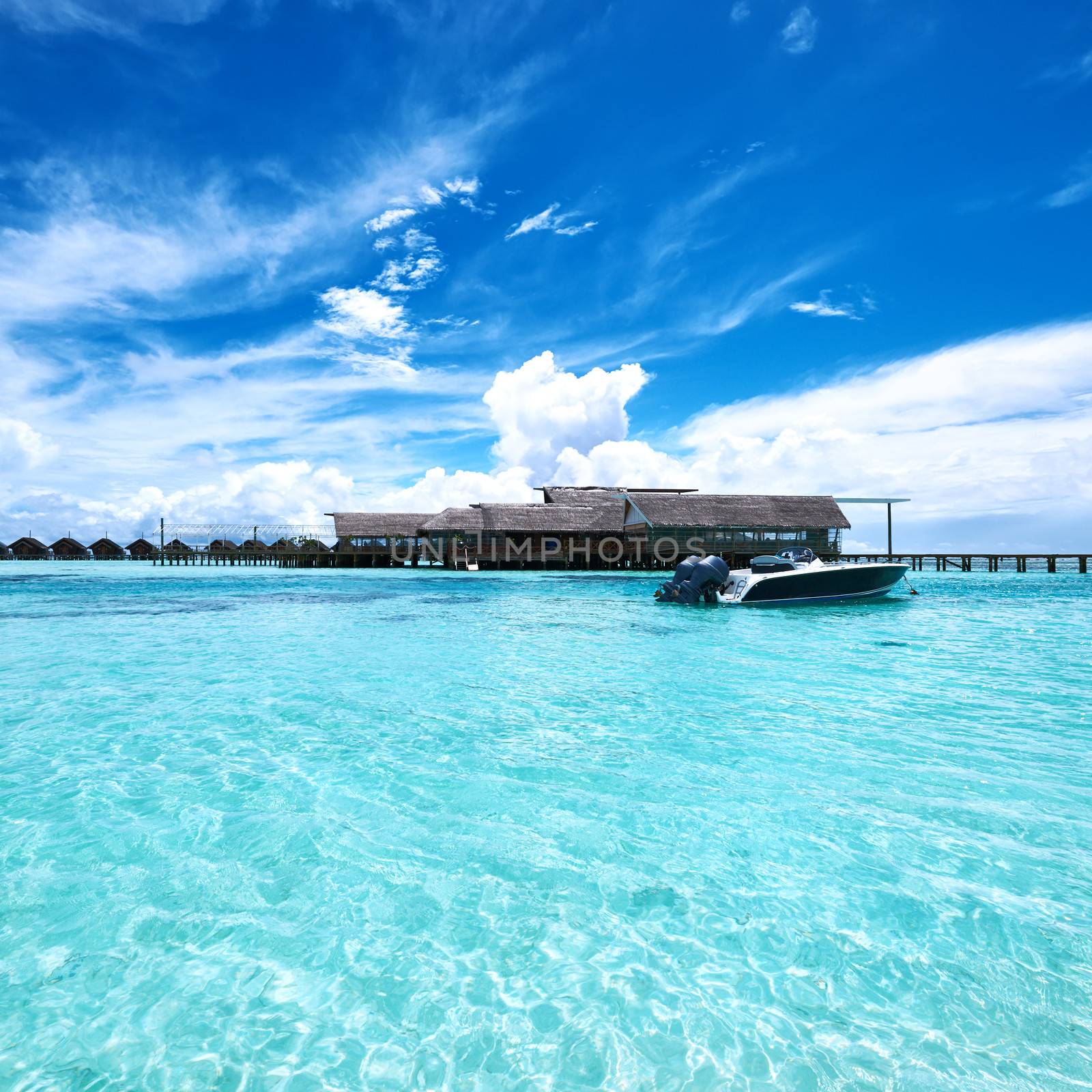 Beautiful island beach with motor boat at Maldives