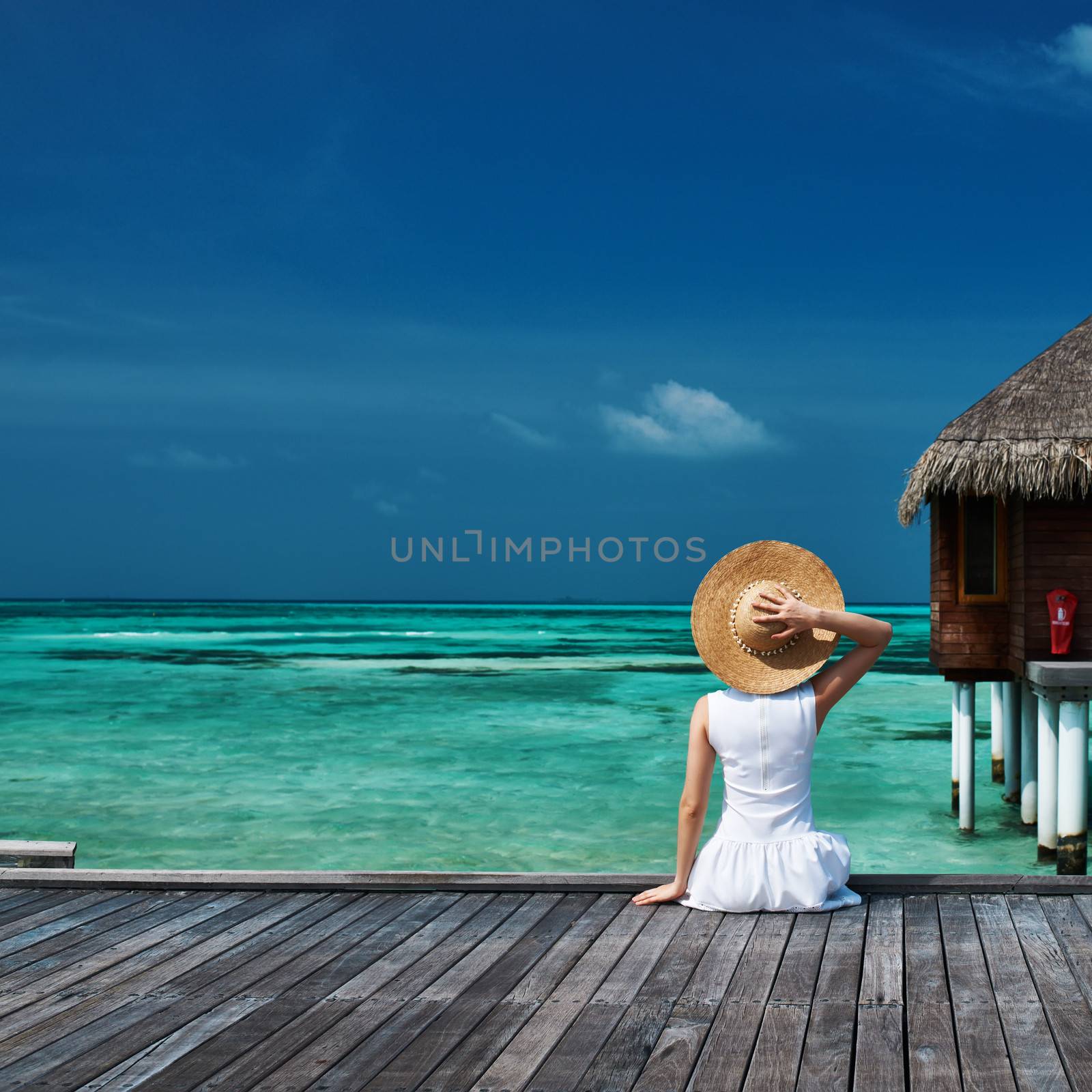 Woman on a beach jetty at Maldives by haveseen