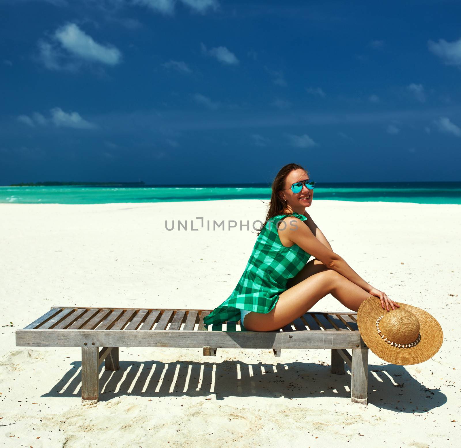Woman in green dress on a beach at Maldives by haveseen