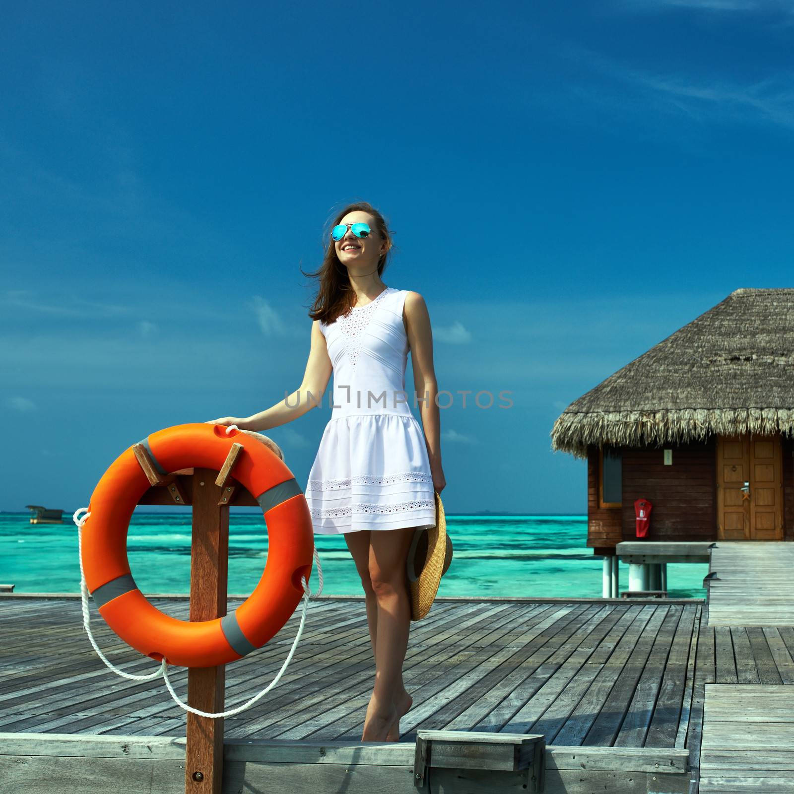 Woman on a tropical beach jetty at Maldives