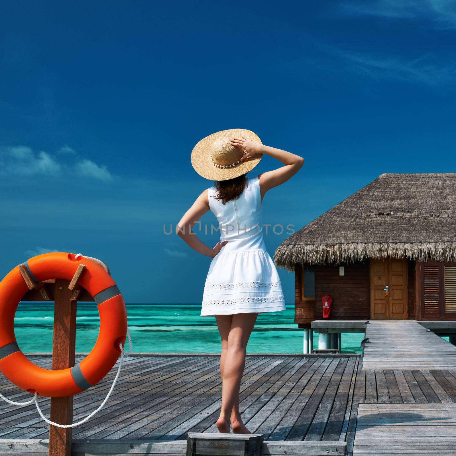 Woman on a tropical beach jetty at Maldives