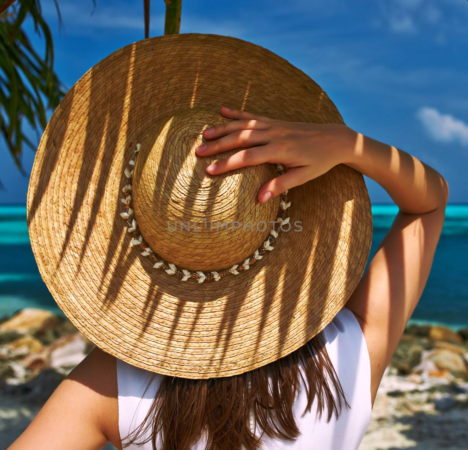Woman with sun hat at tropical beach