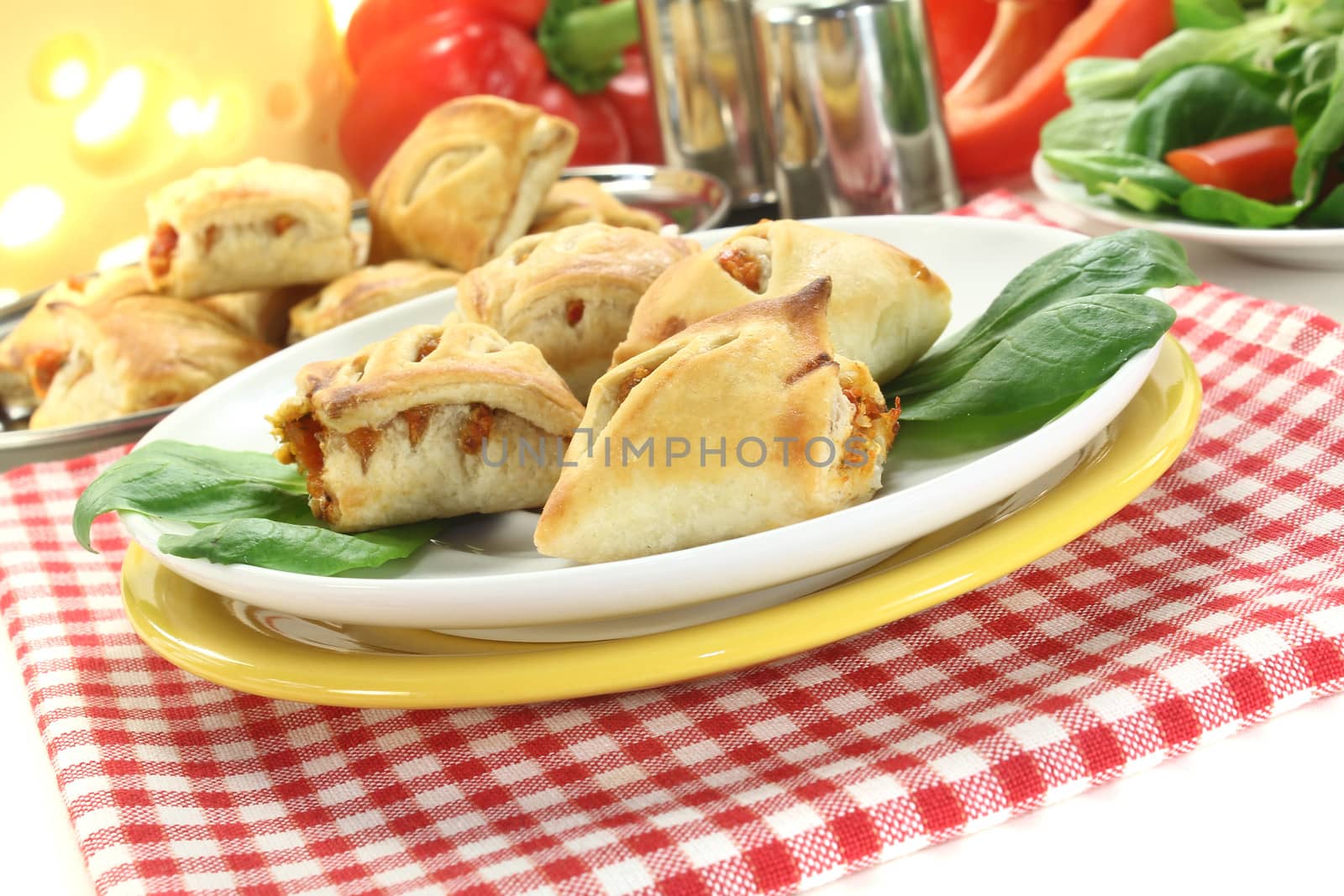Puff pastry with bell peppers, cheese filling and salad on a light background