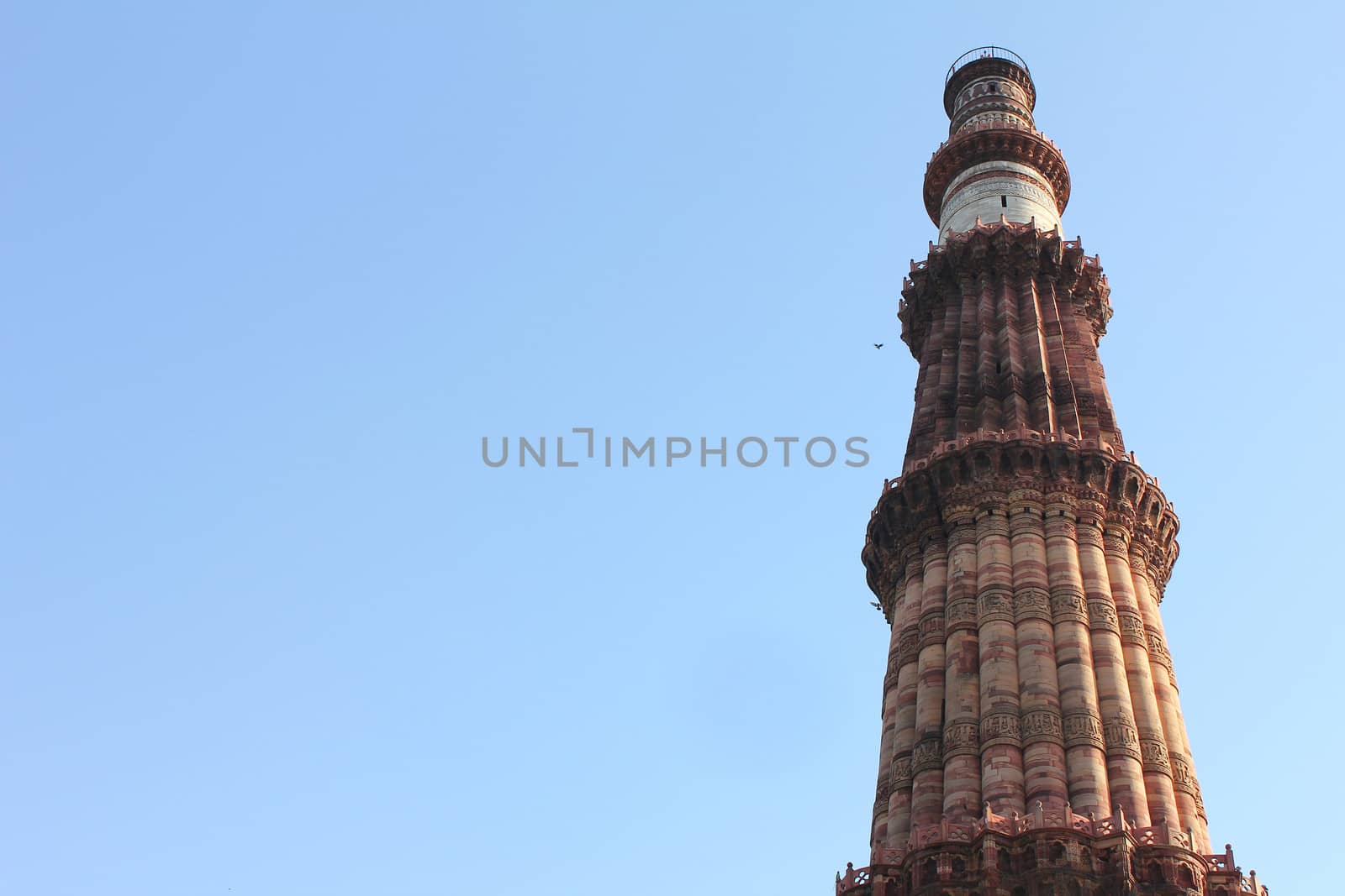 qutub minar with carving architecture in blue sky