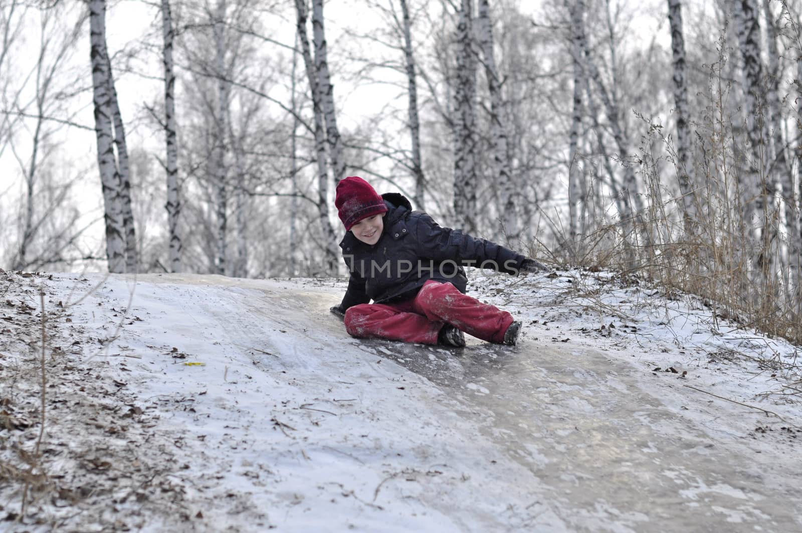 the teenage boy rides from a hill in the snow-covered wood