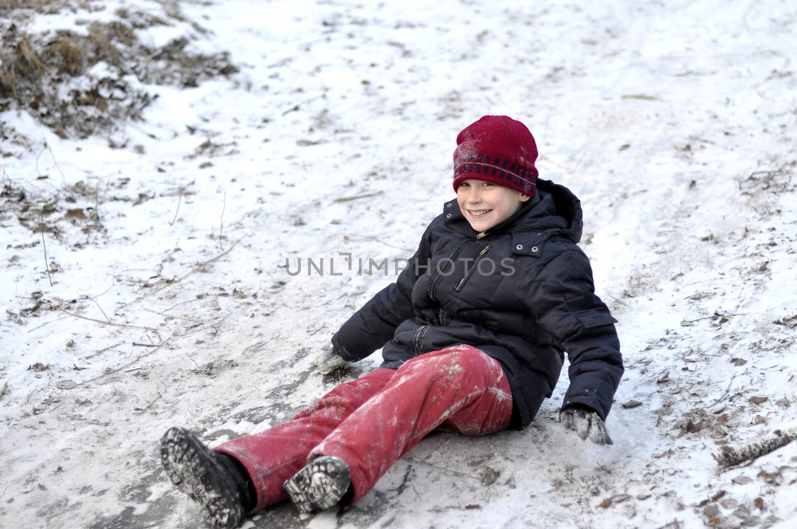 the teenage boy rides from a hill in the snow-covered wood