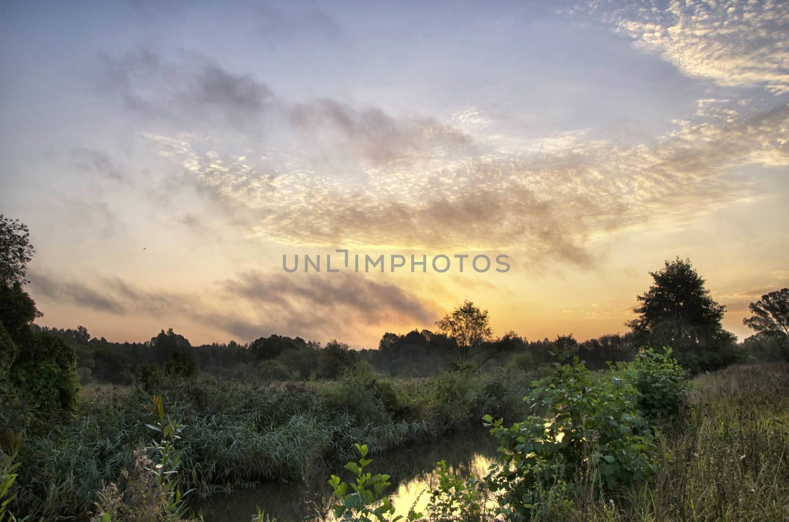 Sunrise over the river with beautiful Golden clouds in summer