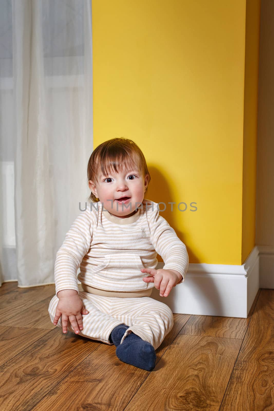 Cute little boy sitting on the floor in the living room