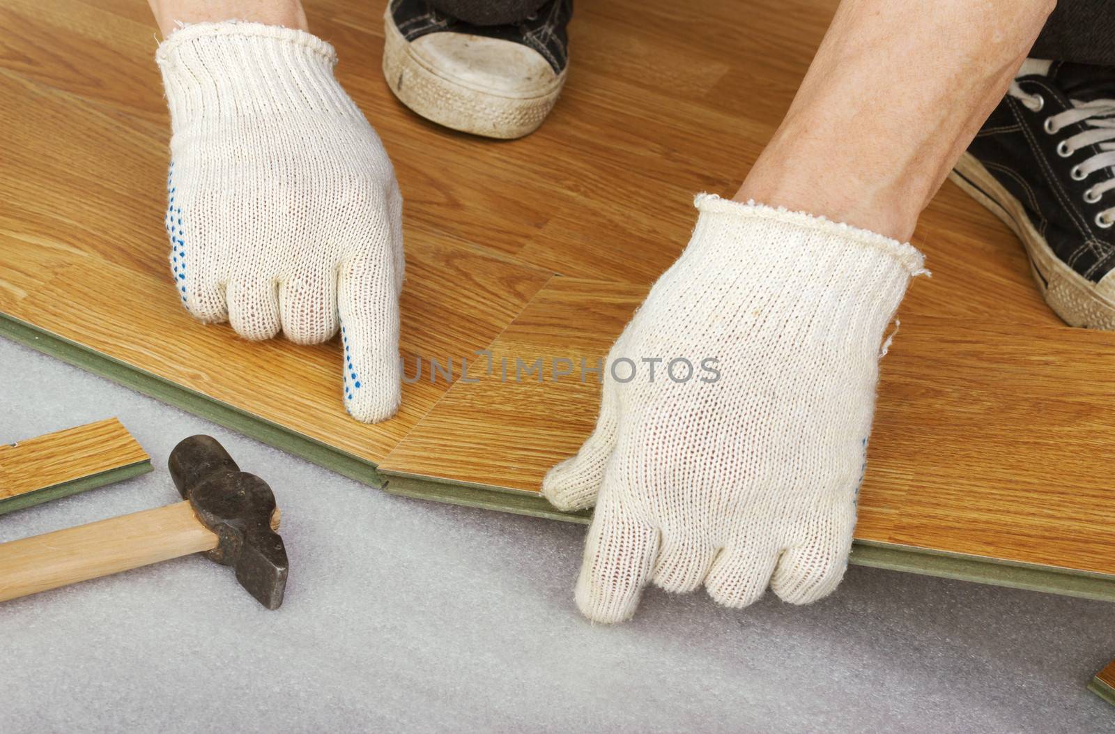 Hands of a master, lay laminate flooring, stylized wood