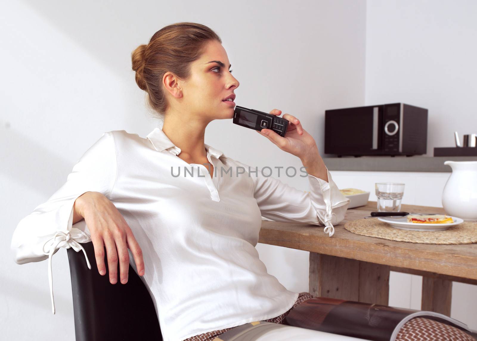 mid adult woman with her mobile phone in kitchen