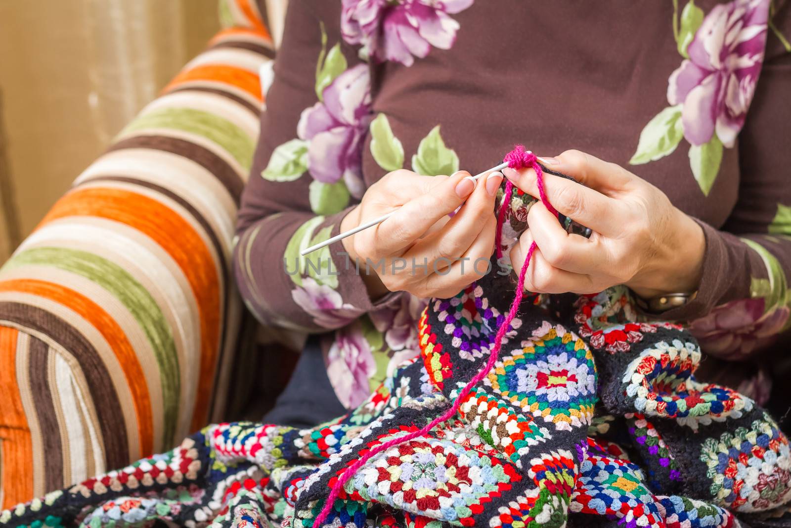 Hands of woman knitting a vintage wool quilt by doble.d