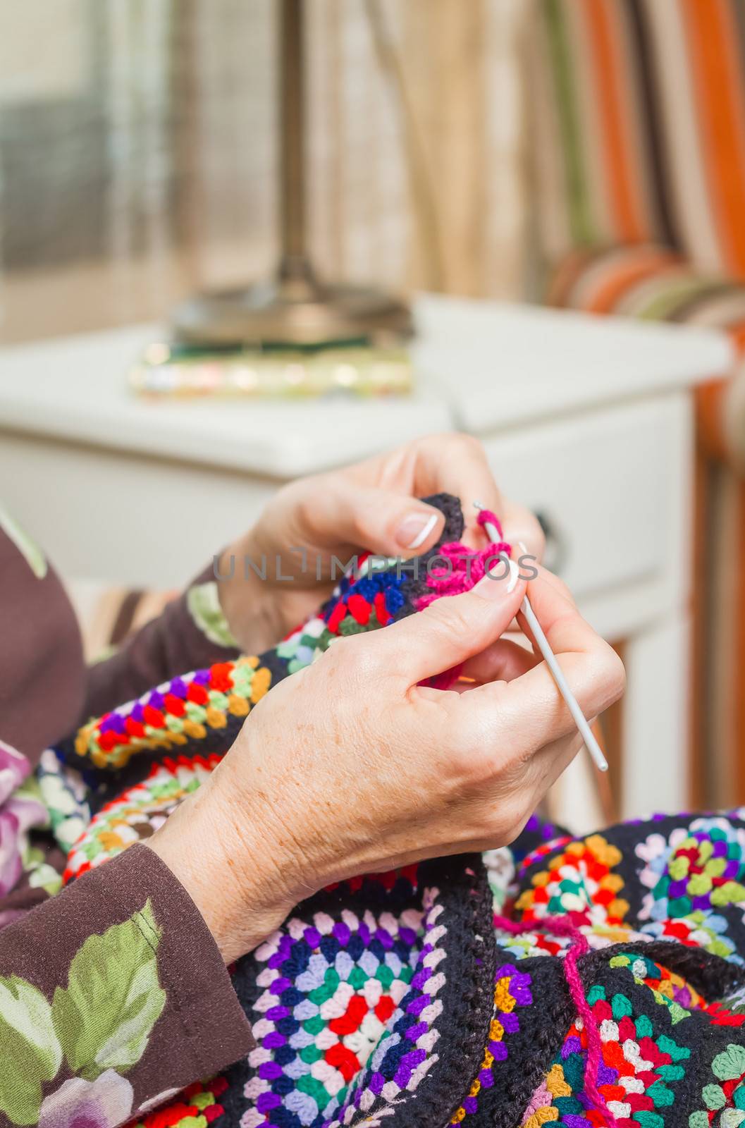 Hands of woman knitting a vintage wool quilt by doble.d