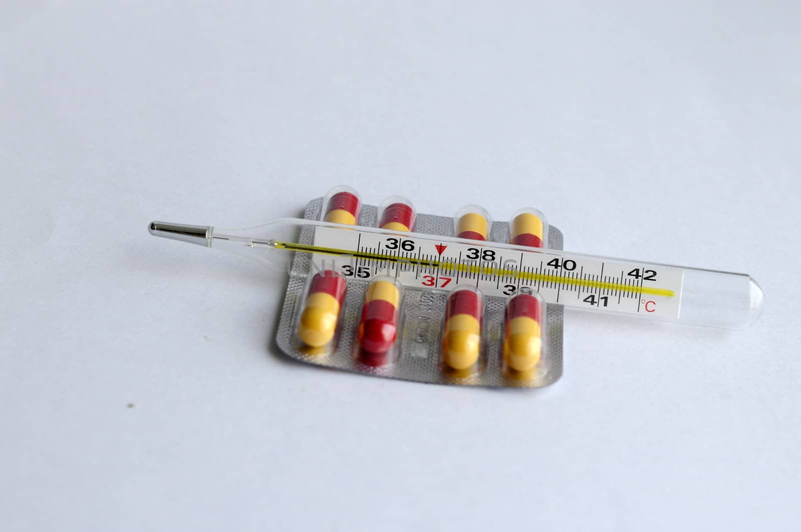 The increased temperature on a thermometer and pills