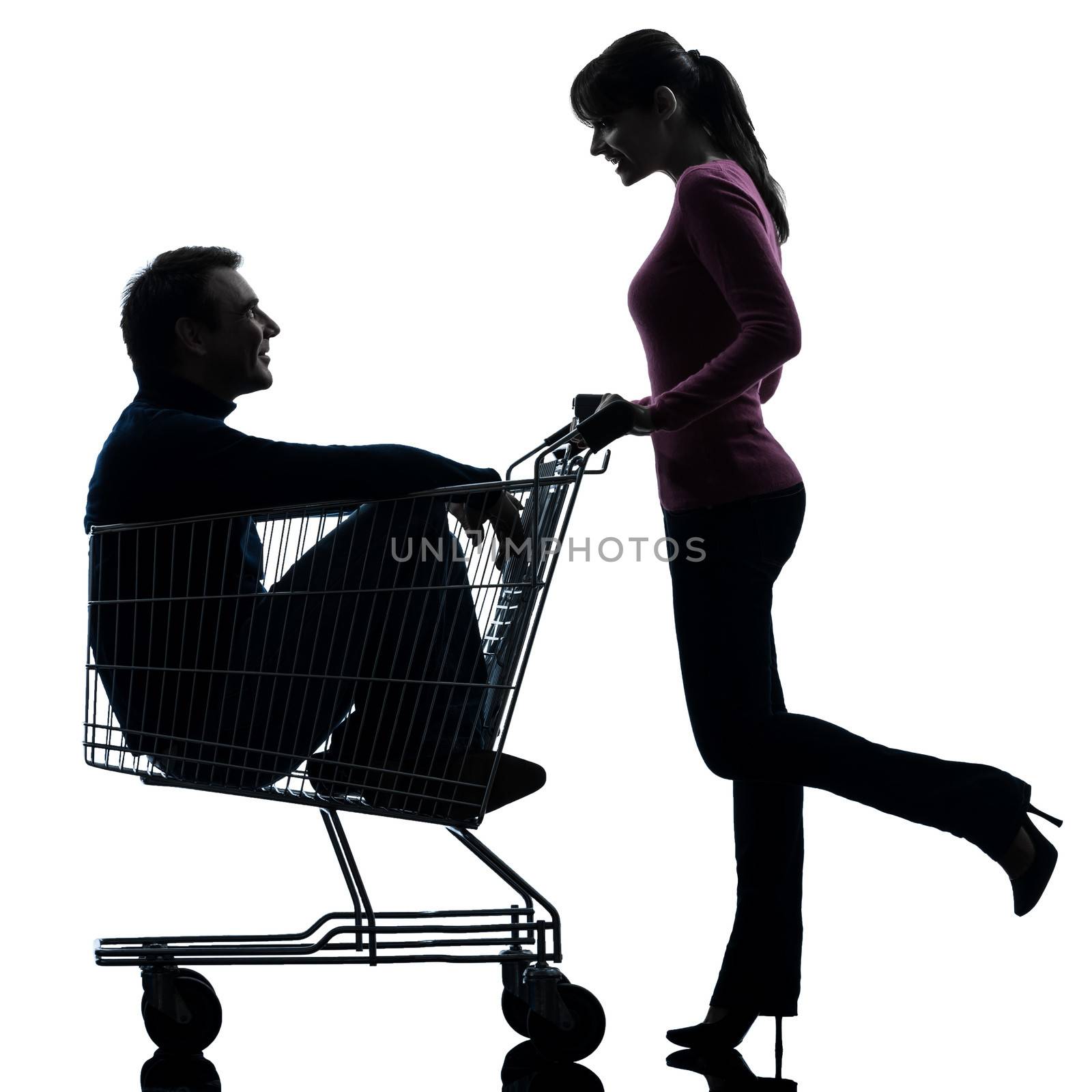 one caucasian couple woman with man sitting in shopping cart  in silhouette studio isolated on white background