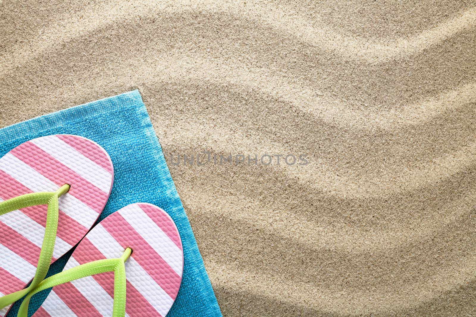 Beach background with towel and flip flops. Summer concept. Top view