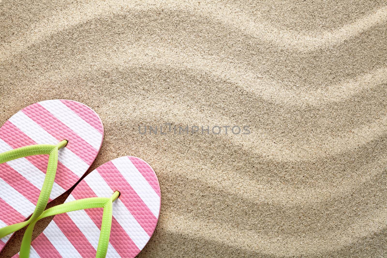 Sandy beach background with flip flops. Summer concept. Top view