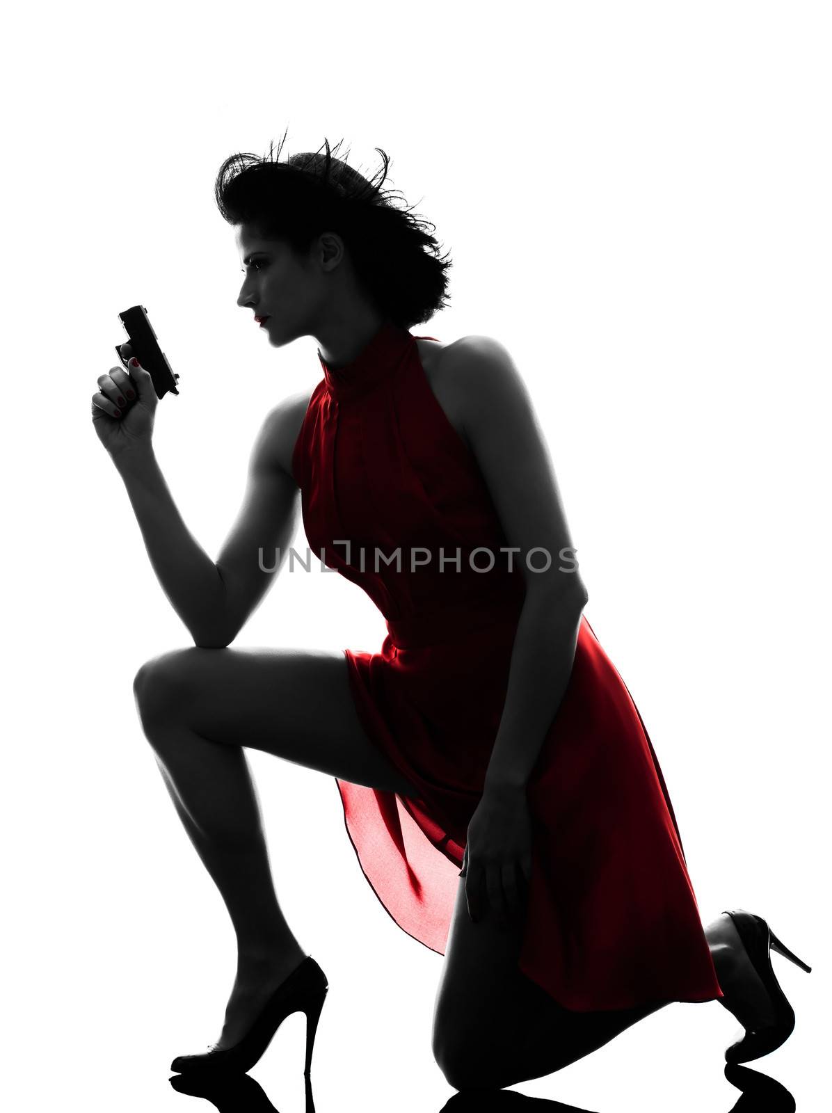 one sexy caucasian woman holding gun in silhouette studio isolated on white background