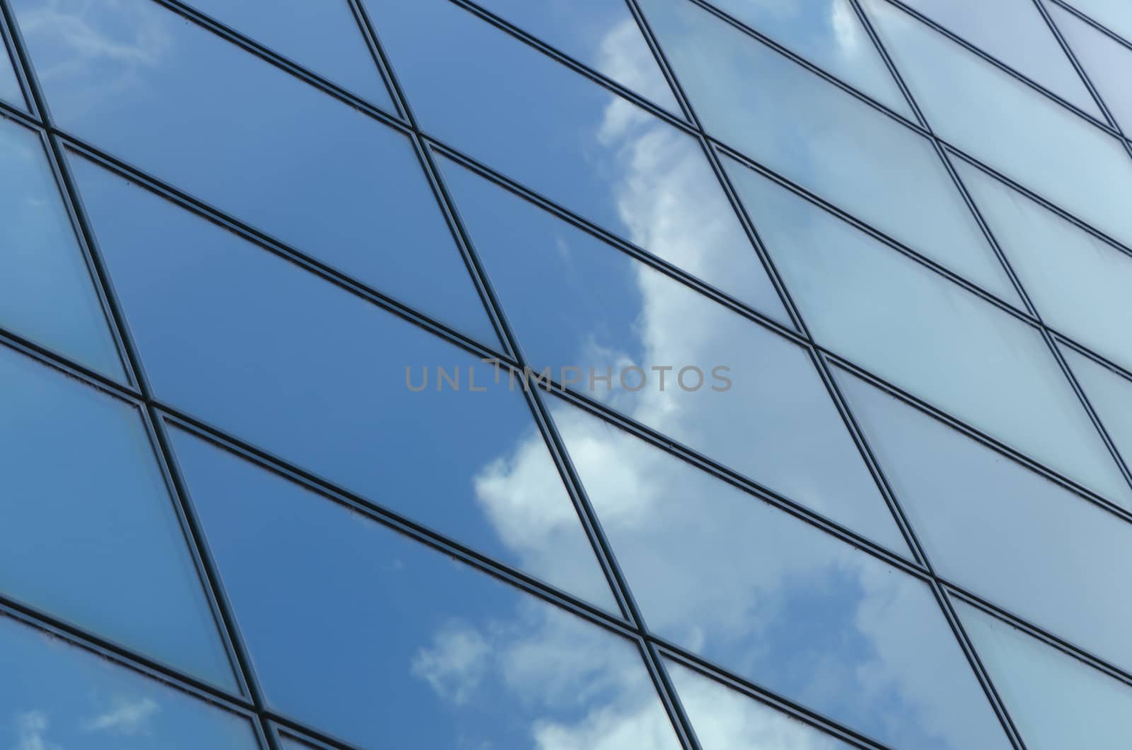 glass surface of a building with reflection of clouds and sky in it