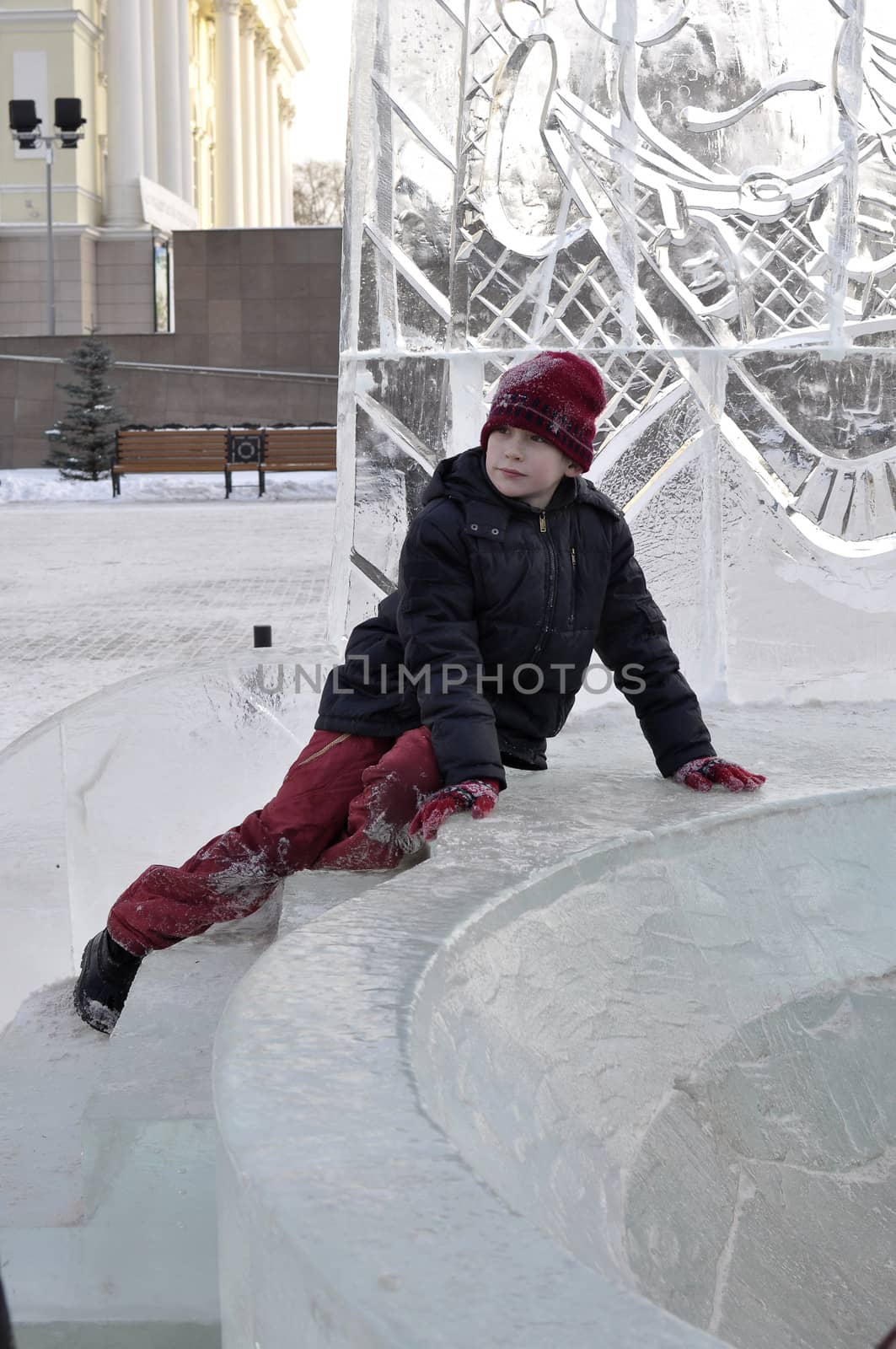 Portrait of the boy sitting on the edge of an ice slope