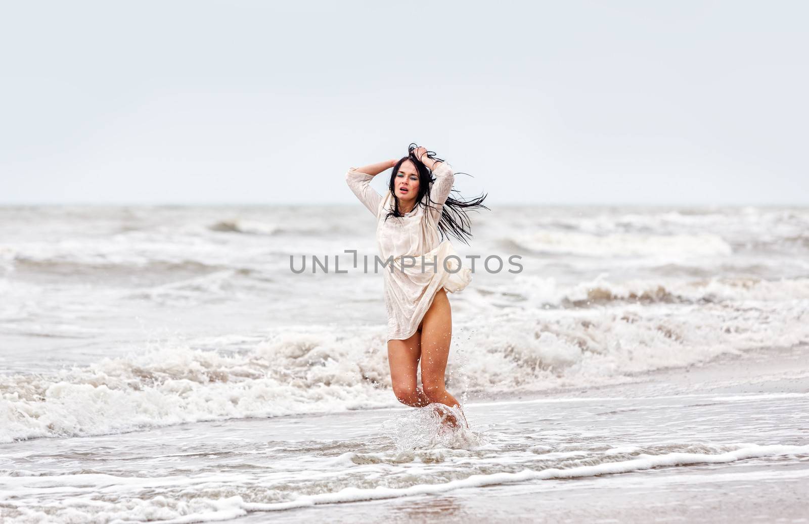 seminude woman in the cold sea waves by palinchak