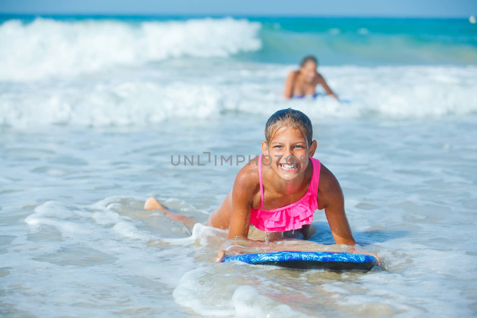 Summer vacation - Happy cute girl having fun with surfboard in the ocean