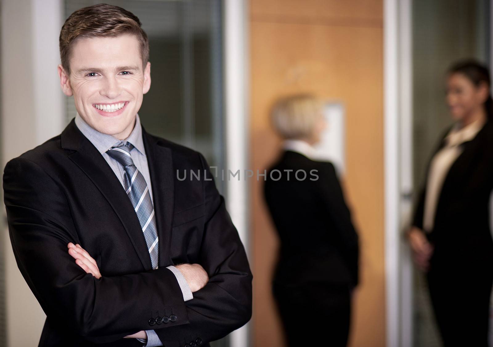 Businessman posing with smart associates behind by stockyimages