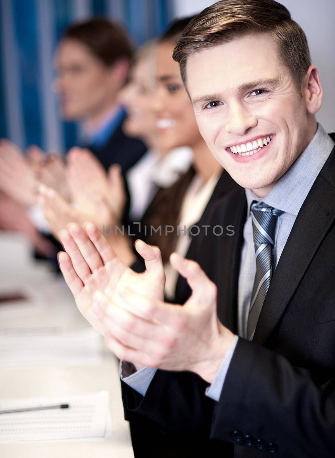 Business associates applauding, focus on guy by stockyimages