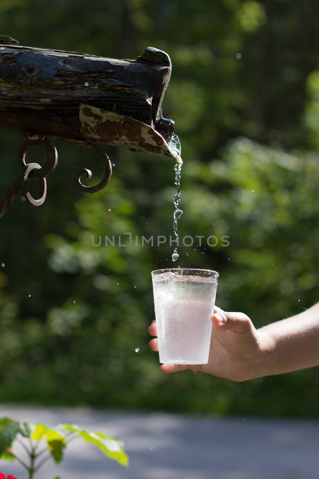 Water dripping from the old faucet to the cup