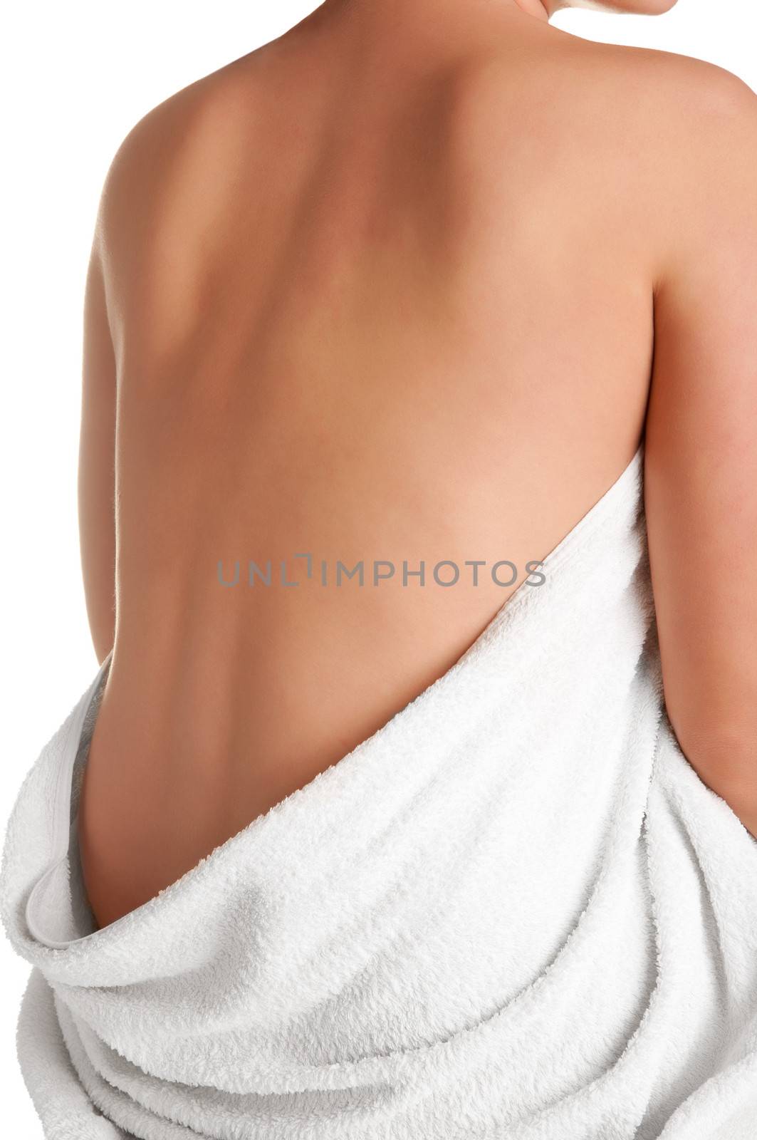 Naked womans back wrapped in a towel, isolated in white