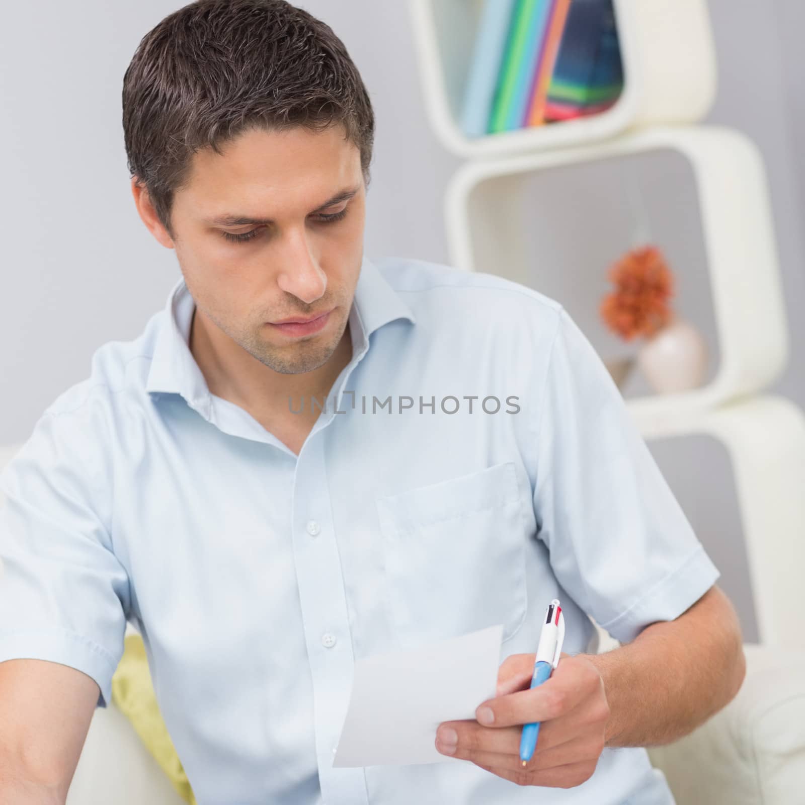 Worried young man paying his bills at home by Wavebreakmedia