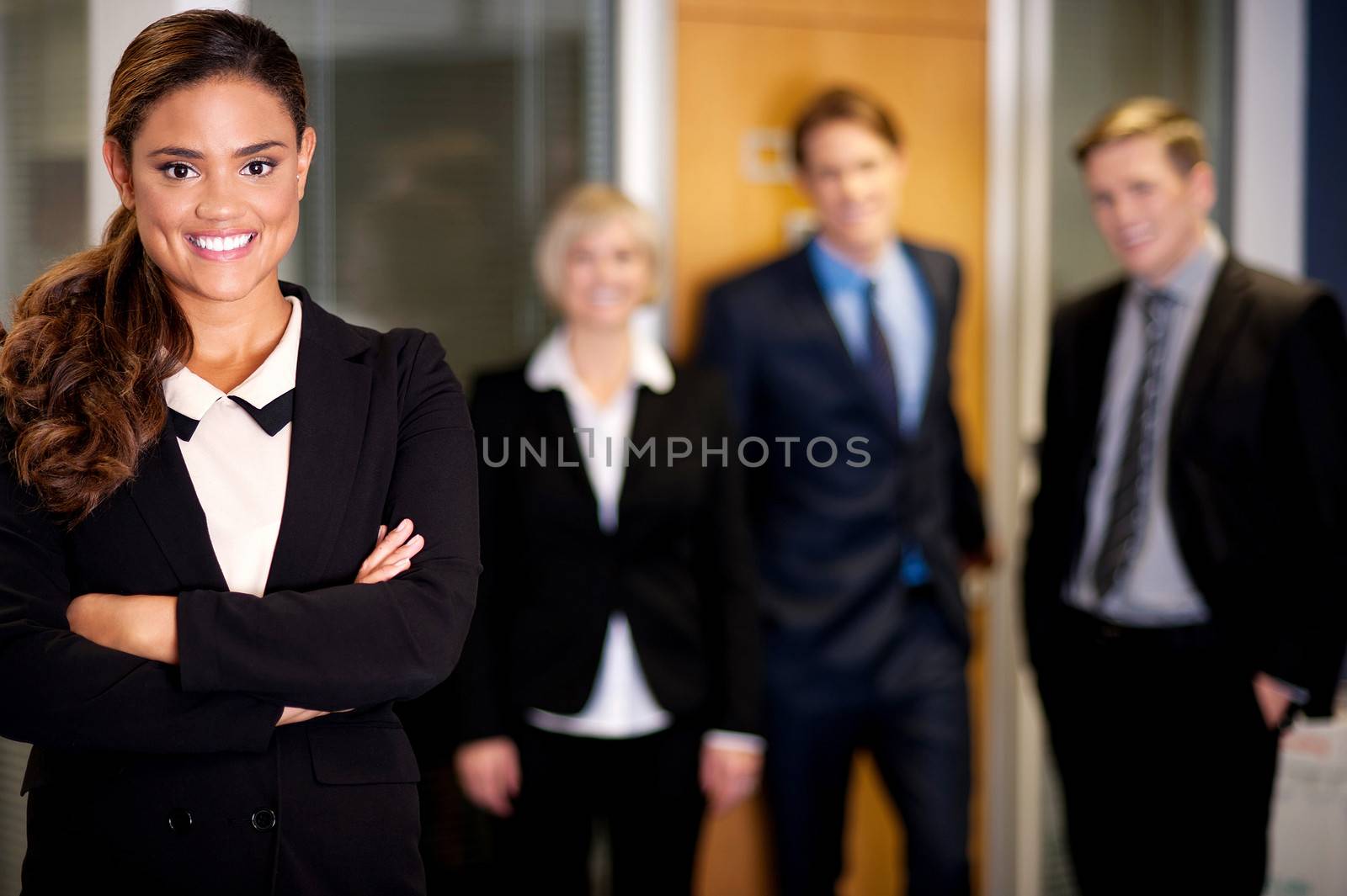 Business woman posing with smart associates behind by stockyimages