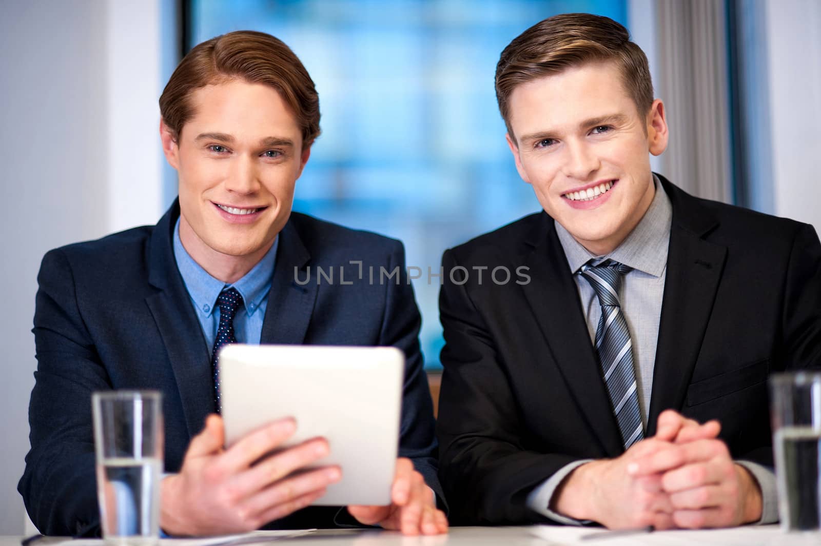 Businessmen browsing on tablet device by stockyimages