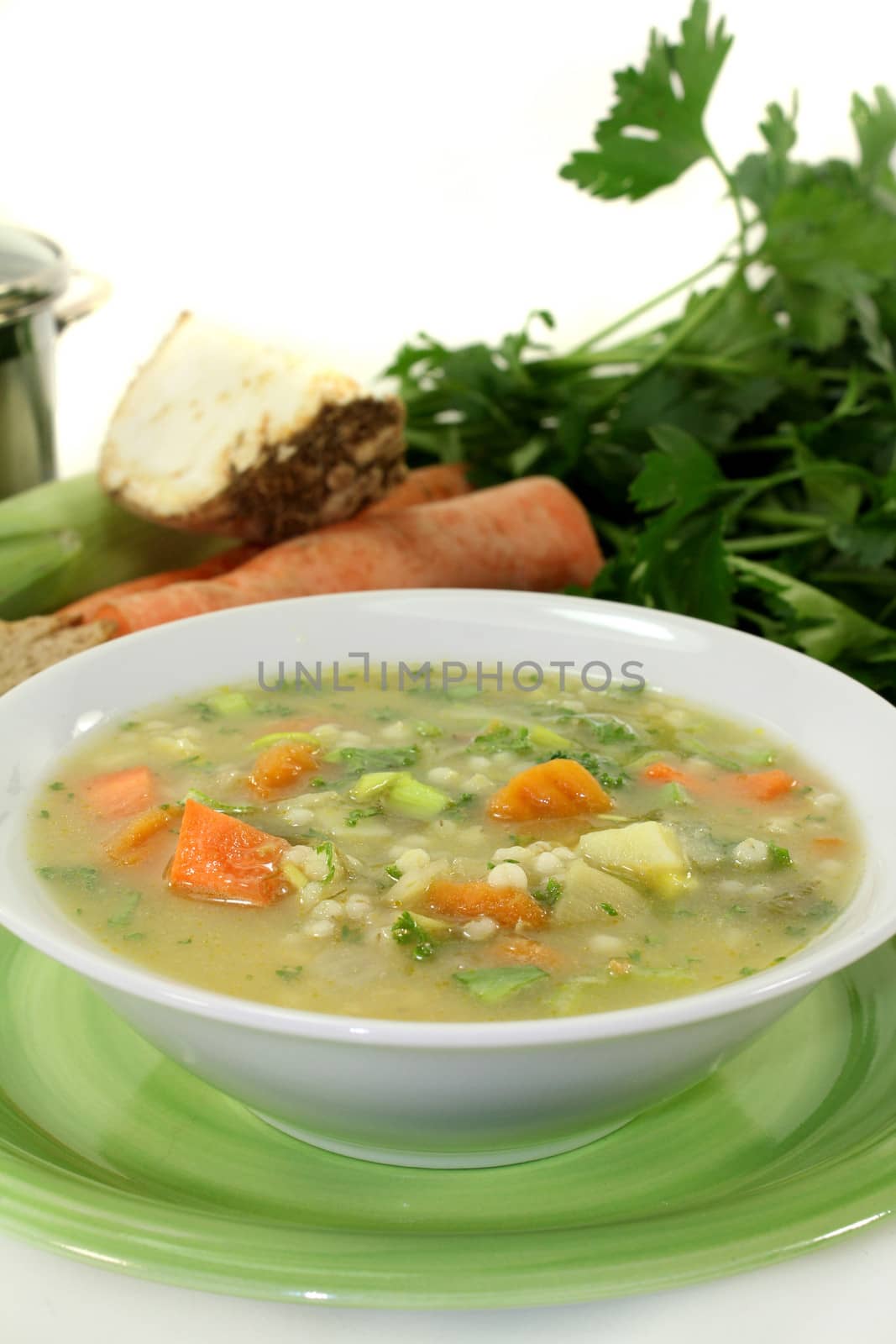 a bowl of colorful barley soup in front of white background