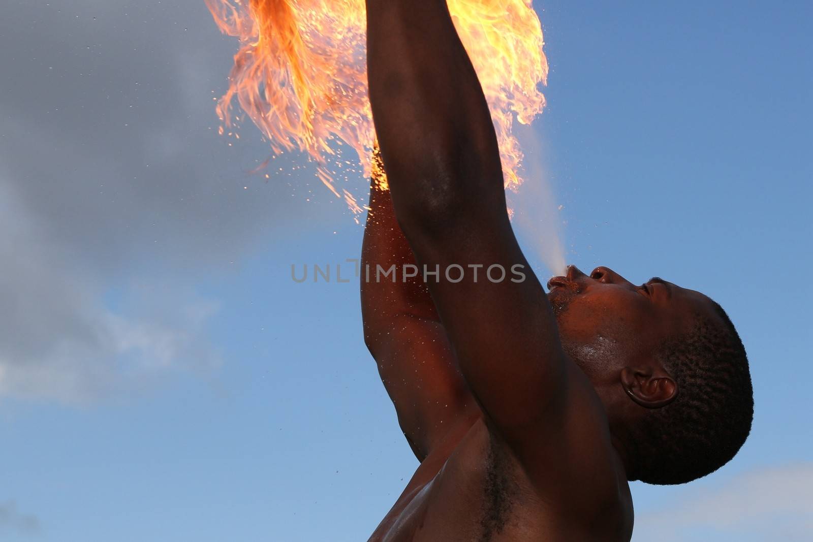 Circus fire-eater blowing a large flame from his mouth