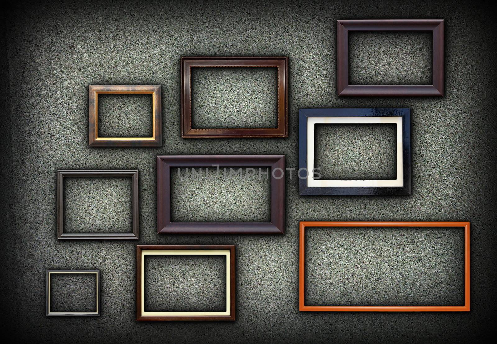 green grungy wall full of wooden picture frames for your design