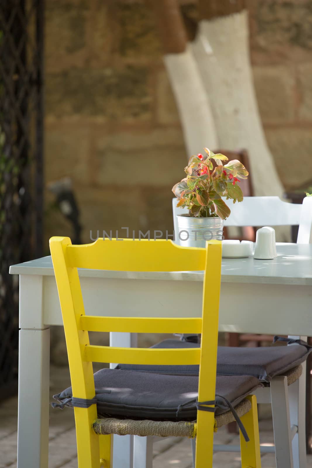 Close-up from a Yellow chair and white table.  by watchtheworld